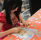 Venus signs autographs for fans at a special event.