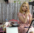 Venus applies makeup as she dresses for the day.