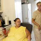 When Paula needs Tara's help in the kitchen, Tara has to sit in a chair and wheel around the floor. She's in constant pain from her weight, and standing too long hurts.