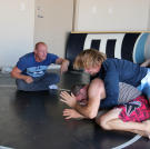 Kody and his friend Brett wrestle while their trainer Sean cheers them on.