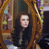 Emily sits at her dressing table to prepare for the day ahead. She wears faux lashes, special contact lenses and long wigs to enhance her doll-like appearance.