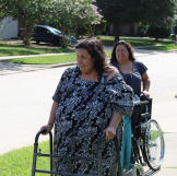 Olivia's sister-in-law follows behind with a wheelchair in case Olivia needs to rest.