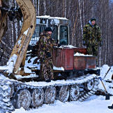 The team trying to fix the skidder. Cold weather can wreak havoc on engines, stress metal and other equipment parts, and kill machine batteries.