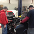 Shawn Ellington (a.k.a. Murder Nova) is working with Tyler Priddy (a.k.a. Flip) on the vehicle in the shop.