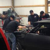 Tyler Priddy (a.k.a Flip), Justin Shearer (a.k.a. Big Chief), Shawn Ellington (a.k.a. Murder Nova) and Danny Parker work on a car together.