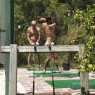 The nudist community is very active; here a few of the residents practice their golf swing at the driving range.