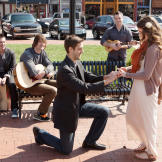 Derick nervously slides the ring on Jill's finger.