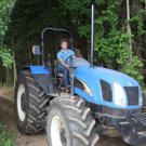 Jeremy drives a tractor through a wooded path on Roloff Farm. Growing up in rural Oregon, Jeremy knows a lot about manual labor and fixing machinery, but he also enjoys biking through rough trails and hiking up tall mountains.