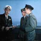 Commander Noorfleet (left) accepts the formal surrender of U-858 from her CO, Kapitänleutnant Thilo Bode (right) aboard ATR-57. The German u boat was the first to surrender in U.S. waters. LT Robert H. Braun (center) served as translator 14 May 1945. Noticed Bode's specially-treated leather pants.