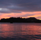The calm waters capture the reflection of a sunset in Alaska.