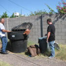 Ed Rosenberg and Scott Menaged search through trash prior to bidding on a house. Evidence of construction materials, such as tile or carpet remnants, offer clues to the interior condition of the home.