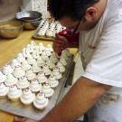 Frankie pipes red icing scarves onto the famous Carlo's Snowman cupcake.