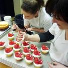Liz and Christine assemble Santa cupcakes.
