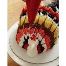 Using the red buttercream, pipe a comb on top of the turkey's head.