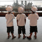 Gosselin boys in sailor hats looking at a model ship at the Battleship North Carolina.