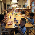 The Gosselins sit down at their table to eat.