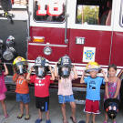 The sextuplets try on fire helmets.