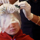 A gypsy boy gets highlights at a hair salon.