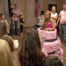 Danielle pops out of a giant birthday cake at her party.