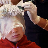 A gypsy boy gets highlights at a hair salon.