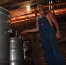 Josh stands next to a stainless "steel steam still."