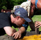 Tickle and Tim try to pry a huge tire off its rim.