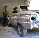 Billy Derian Jr. and Shane Tait sand down a 1963 Falcon Spirit to get ready for paint.