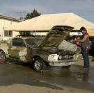 Billy Derian Jr. power washes a 1967 Ford Mustang.