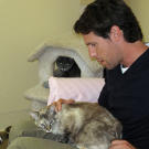 John hangs out with two cats while on the road during filming.