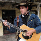 John in costume playing guitar.