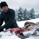 Les Stroud cleans a fresh kill in the snow.