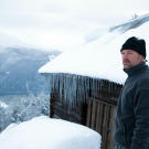 Les Stroud in front of a modest shelter in the extremely cold Norwegian weather.