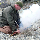 Dave shows how to get a fire going with the sparking percussion action of a black powder rifle.