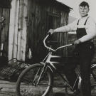 John shows off the bike he bought in 1933 with his earnings from delivering newspapers. John also made money selling used bottles to bootleggers. He collected the bottles in the alleys of Klamath Falls (an early recycler!) and sold them for a penny apiece. Sometimes he could make as much as 15 cents a day!