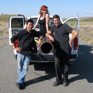 Grant, Tory and Kari posed with the ball-chucker they built to test whether an object fired backward from a vehicle moving forward will simply fall straight to the ground. Can you guess the year? (No need -- it was 2010.)