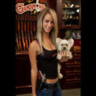 Paige poses in the Gunsmoke shop with two of her favorites: her dog Malibu and the Colt Defender on her hip.