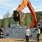 A camera and sound team catches the action as Todd and Dorsey secure the cables used to raise the shaker.