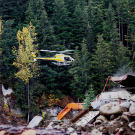 In one of the more dangerous production shoots, a helicopter with a camera crew makes a low pass over the wash plant and camp. Aerial footage is an essential component of adventure productions but it always carries the risks inherent in wilderness flights.