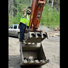 A cameraman rigs a remote mini-cam on the arm of the 400 excavator. Dozens of small cameras were used to capture equipment action while keeping camera crews safe from the hazards of heavy mining operations.