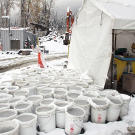 Buckets of "pay dirt" — topped off with icy slush after a freeze — await final refinement outside the processing tent that contains wave tables, pans and a variety of experimental machines all designed to separate black sand from gold. In a final pass at recovering as much gold as possible, the remaining dirt is all manually panned.