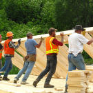 Jimmy Dorsey, Jim Thurber and a crew of local builders work together to raise the main cabin, the first building erected in their mining camp with materials brought from Oregon. After this build, each of the men on the Hoffman team set to work on their own shelters; some of these needed to be large and sturdy enough to house the men's families.