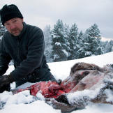 Les Stroud cleans a fresh kill in the snow.