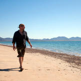 Les Stroud walks on a beach on Tiburon Island looking for items to salvage.