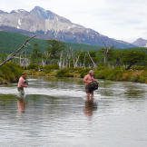 Stripped to their skivvies, the pair wade through a frigid river with their clothes high and dry. Brief pain is much better than the threat of hypothermia that comes with soaked clothing.