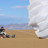 Using his reserve parachute and an improvised buggy, Bear Grylls tries to reserve energy and avoid unnecessary dehydration by using the wind to propel him across a dry lake bed in Arizona.