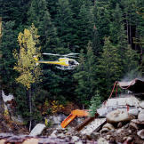 In one of the more dangerous production shoots, a helicopter with a camera crew makes a low pass over the wash plant and camp. Aerial footage is an essential component of adventure productions but it always carries the risks inherent in wilderness flights.