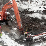 Jack Hoffman operates the excavator in the glory hole pit hoping to hit a quick jackpot. The location of the glory hole — a name given to deposits at the base of ancient waterfalls that often have high gold concentrations — was suggested by the miner on an adjacent claim. Digs at this depth typically flood so pumps are required to keep the excavation going.