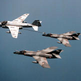 Merci! Two French Navy Super Etendards replentish their fuel thanks to a US Navy A-6E Intruder and its belly-mounted buddy pack over the Western Mediterranean, June 1996.