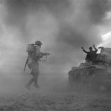 A posed photograph of a German soldier surrendering to British infantry after his PzKpfw III tank was knocked out during fighting in the Western Desert, Nort Africa, October 1942.