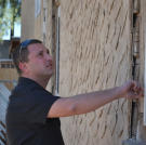 Scott Menaged inspects the windows of this house to assess the cost of upgrades.